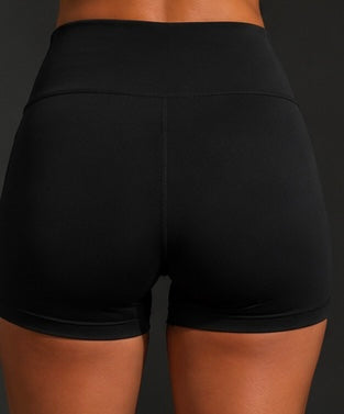 Black high-waist performance shorts with smooth waistband seam detail (back view close-up).