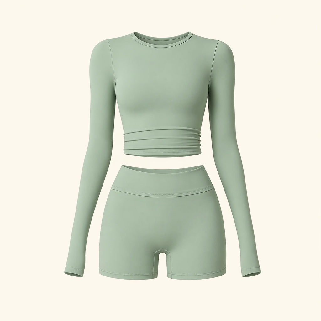 Sage activewear set flat lay: long-sleeve cropped top and high-waist biker shorts