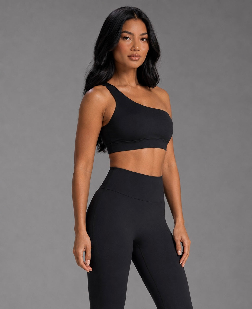 Black asymmetrical one-shoulder sports top with cropped length, sleek fit