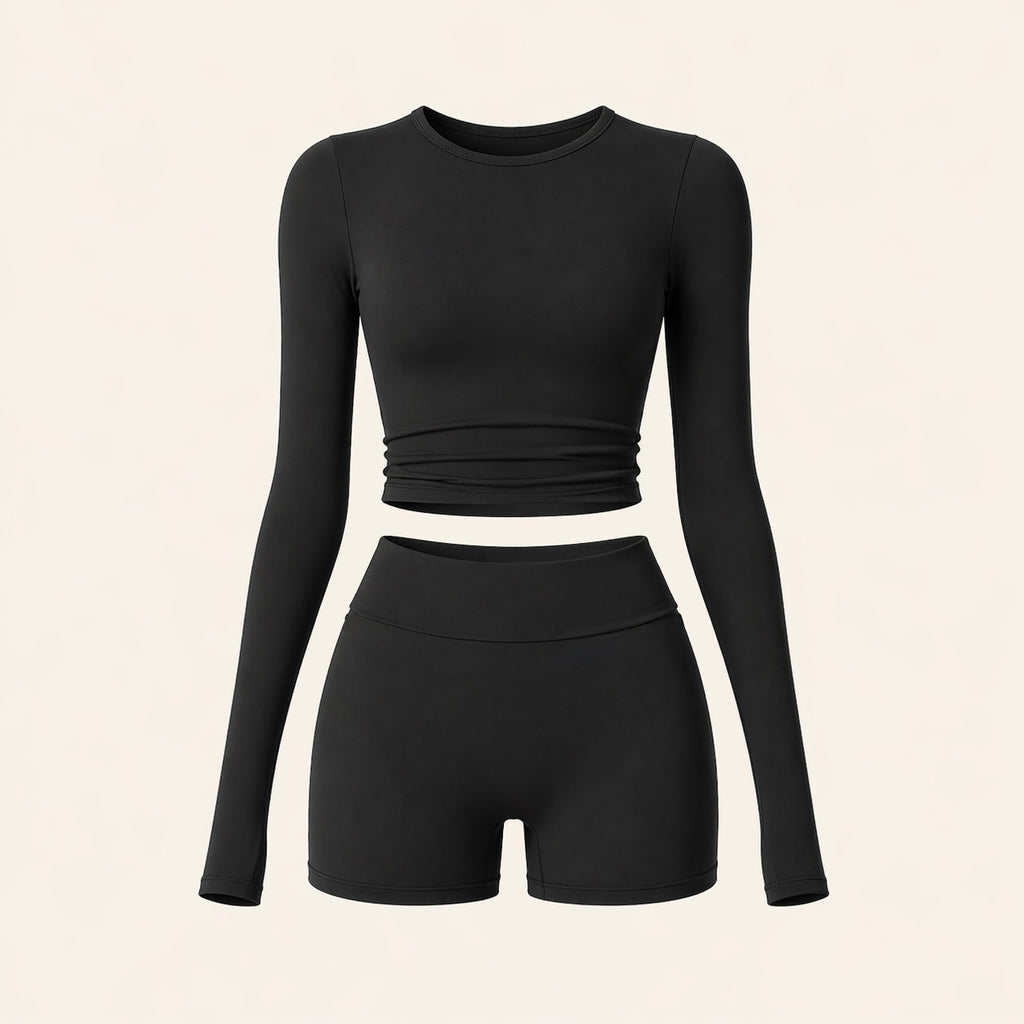 Black activewear set flat lay: long-sleeve cropped top and high-waist biker shorts