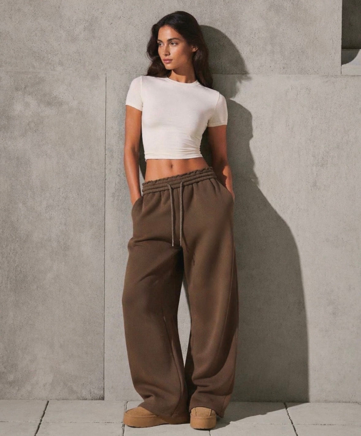 Brown oversized sweatpants with elastic waistband and drawstring, relaxed wide leg fit.