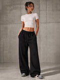 Black oversized sweatpants with elastic waist and drawstring, relaxed wide legs.