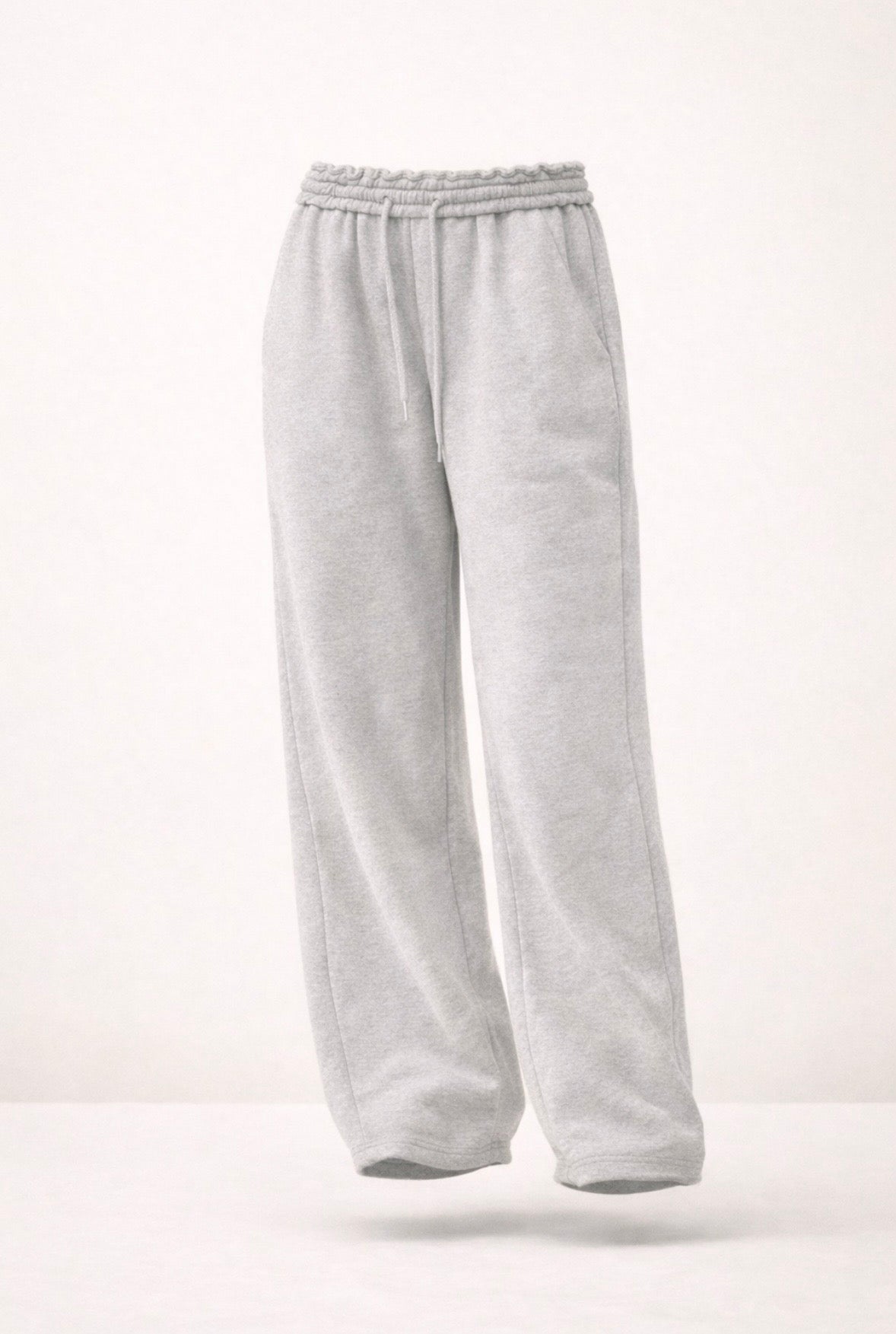Light grey oversized sweatpants with elastic waistband, drawstring, loose wide legs.