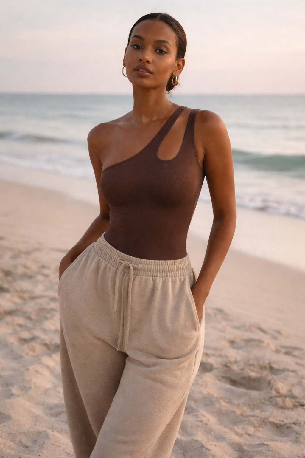 Asymmetrical one-shoulder sculpting bodysuit in cocoa brown, with side cutout.