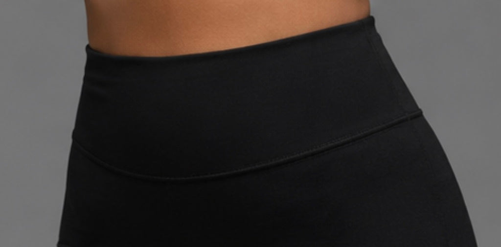 Black high-waist athletic shorts, wide waistband fabric close-up