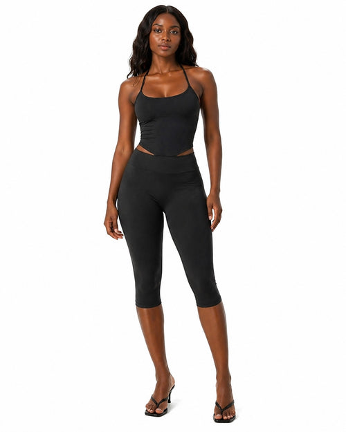 Black strappy crop top and high-waist capri leggings set with diagonal front cutout