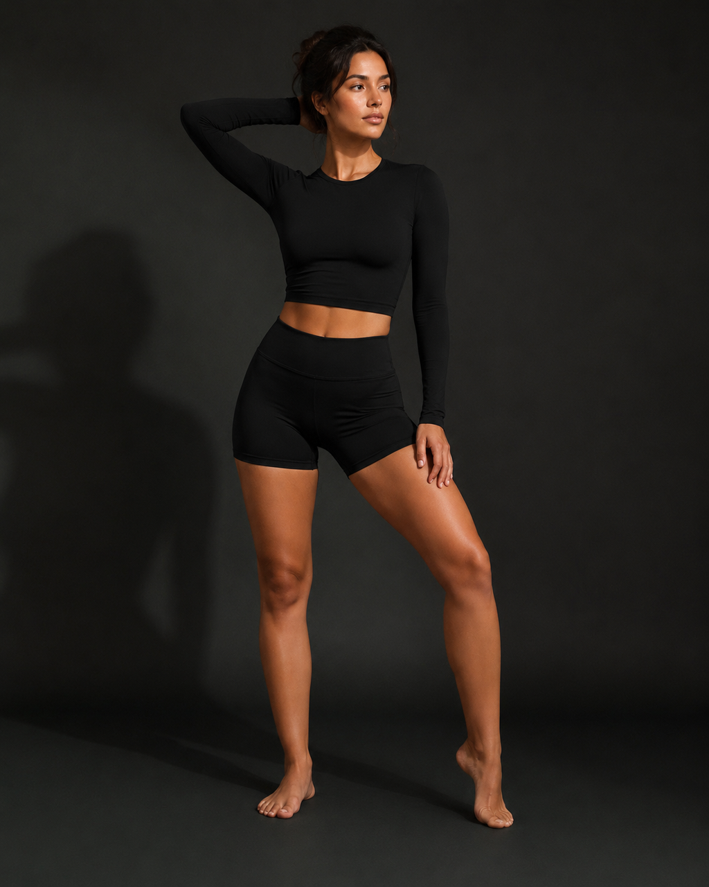 Black performance activewear set with long-sleeve cropped top and high-waist shorts (front view).