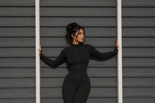 Black zip-up jacket with high neck, fitted long sleeves, front zipper