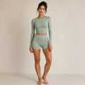 Sage activewear set with long-sleeve cropped top and high-waist biker shorts
